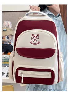 Detail of student backpack featuring burgundy color block and cute cat embroidery.