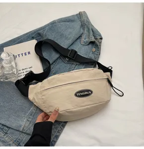 Detailaufnahme einer beige Workwear-Brusttasche mit TENGRUN-Patch und schwarzem Gurt.