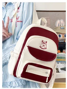 Close-up detail of cute academy style color-block backpack with cat embroidery decoration