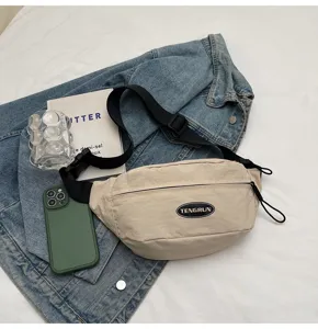 Detailansicht der beigen Utility-Brusttasche mit schwarzem TENGRUN-Logo-Patch und Gurt