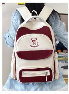 Detail view of cute burgundy and white color-blocked student backpack with cat embroidery