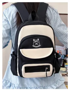 Detail view of a black and white contrast school backpack with cute cat embroidery.
