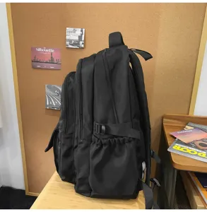 Vue latérale du grand sac à dos noir multi-compartiments avec détail de poche latérale