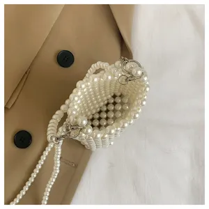 Close-up detail of a handmade pearl woven mini crossbody bag showing bead texture.