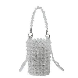 Macro view of a clear beaded woven mini bag featuring transparent beads and handle