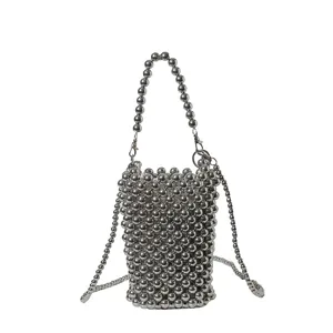 Close-up of fashion silver beaded phone bag with metallic woven texture and chain strap