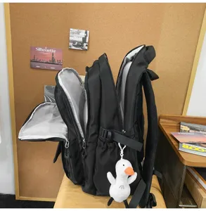 Vue détaillée d'un sac à dos noir spacieux avec plusieurs compartiments et un canard