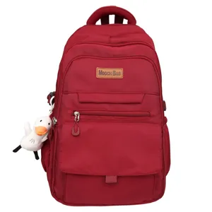 Vue détaillée du sac à dos scolaire bordeaux doté d'un joli porte-clés en canard