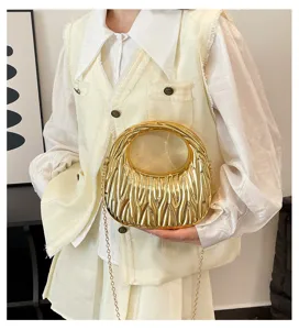 Close-up of a stylish gold metallic textured hobo handbag with a long gold chain strap