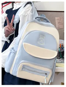 Cute blue and cream color-block school backpack worn by student in cozy study room