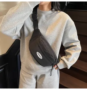 Detailansicht der schwarzen Workwear-Brusttasche mit verstellbarem Gurt, getragen auf Sweatshirt.