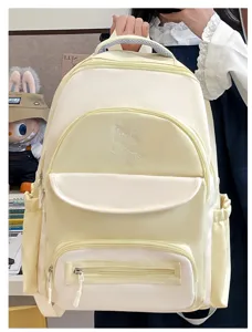 Close-up of a cream and yellow color-block student backpack with cute cat embroidery