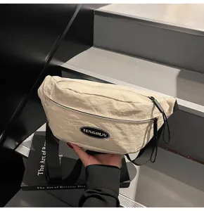 Detailansicht einer cremefarbenen Utility-Brusttasche mit TENGRUN-Patch und Strukturstoff
