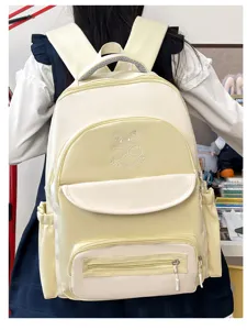 Back view of a cream and yellow school backpack featuring a cute cartoon cat embroidery