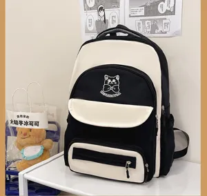 Macro view of a black and cream color-block backpack sitting on a white display shelf