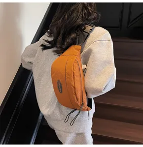 Detailansicht einer senfgelben Utility-Nylon-Umhängetasche, die auf dem Rücken getragen wird.