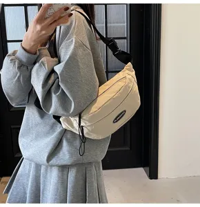 Detailansicht der trendigen cremefarbenen Nylon-Schultertasche getragen von einem Modell