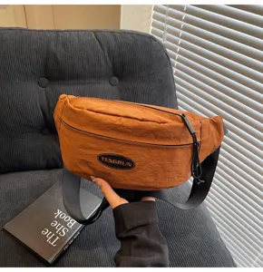 Detaillierte Handheld-Makroansicht einer orangefarbenen Brusttasche aus Nylon mit Logo