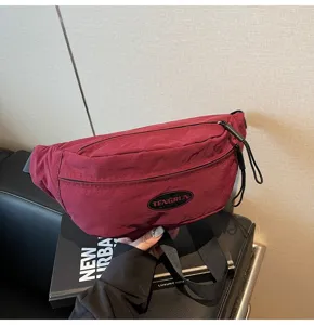 Nahaufnahme einer burgunderroten Nylon-Umhängetasche mit TENGRUN-Label und Reißverschluss