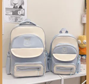 Detail of cute color-blocked student backpacks in blue and cream with cat motif