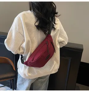Model mit einer minimalistischen weinroten Unisex-Brusttasche für Streetstyle-Look