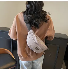 Detail einer grauen Nylon-Umhängetasche, getragen von einer Person in der Rückansicht