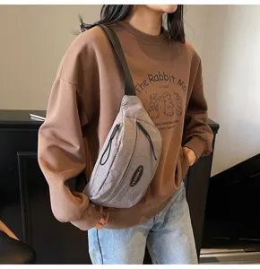 Detaillierte Ansicht des grauvioletten Nylongewebes und Logo-Patches einer Techwear-Brusttasche