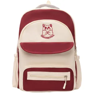 Detail of cute color-block school backpack with red cat embroidery and multiple zippers