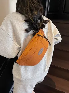 Lässige orange Unisex-Brusttasche mit Patch-Detail, von Model auf Treppe getragen