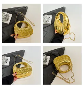 Macro details of gold textured acrylic evening bag with a metallic chain strap.