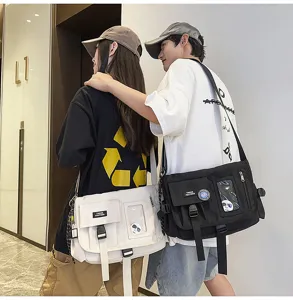 Two models wearing black and white nylon messenger bags in urban street style