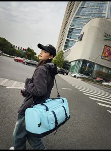 Modella con una grande borsa da viaggio azzurra su sfondo stradale urbano moderno