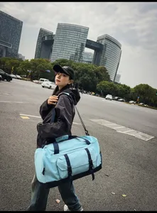 Grande borsa sportiva azzurra per viaggi e fitness portata da una modella asiatica