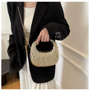 Detailed shot of a gold metallic textured acrylic handbag with a circular handle and chain strap