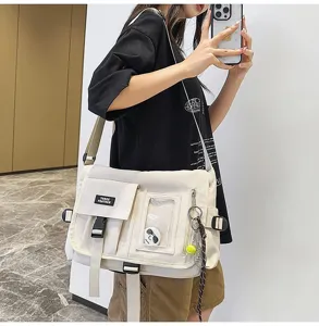Close-up of a beige nylon messenger bag with adjustable strap and functional pockets.