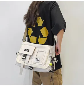 Close-up view of a white nylon workwear messenger bag worn by a student model in casual style