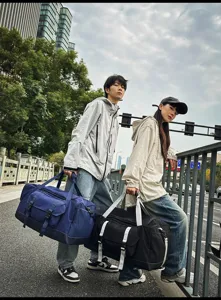 Modelli con borse da viaggio trendy di grande capacità in un ambiente urbano all'aperto