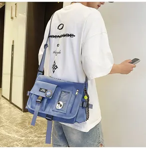 Close-up of blue nylon messenger bag worn by male model in urban setting