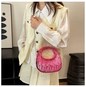 Close-up of candy pink metallic handbag with unique pleated texture and chain strap
