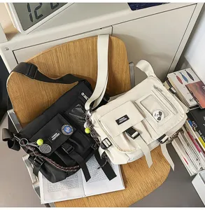 Two nylon messenger bags in black and cream displayed on a chair in a study setting