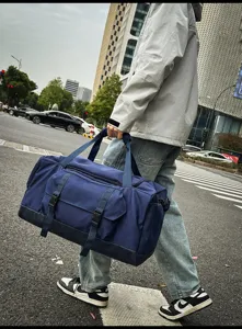 Vista lifestyle di una borsa da viaggio blu navy capiente e alla moda per ogni uomo