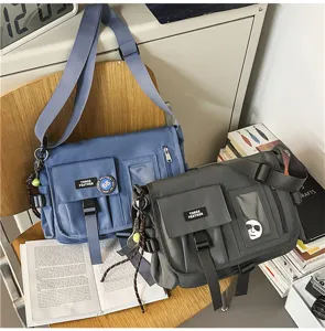Detail view of nylon messenger bags in blue and charcoal grey for students.