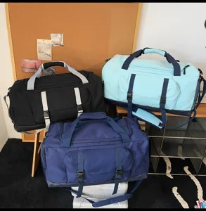 Primo piano di tre grandi borse da viaggio sportive in nero, azzurro e blu scuro