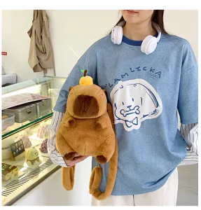 Detail showing a girl holding a cute brown capybara plush backpack in a modern cafe setting