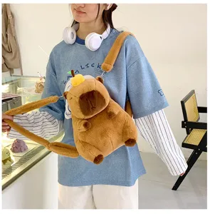Close-up detail of a cute brown capybara plush backpack featuring an orange decoration