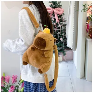 Detailed view of a cute brown plush capybara backpack worn by a model in a room