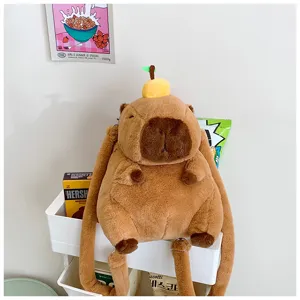 Detailed shot of a cute brown plush capybara backpack with orange decor on a tray