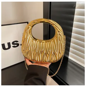 Detail of gold metallic handbag with pleated matelassé texture and chain strap