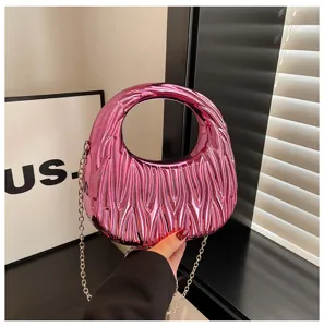 Close-up of metallic pink acrylic handbag with unique crinkled texture and chain strap