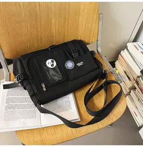 Detail of a black nylon student messenger bag with buckles and card slot on a chair